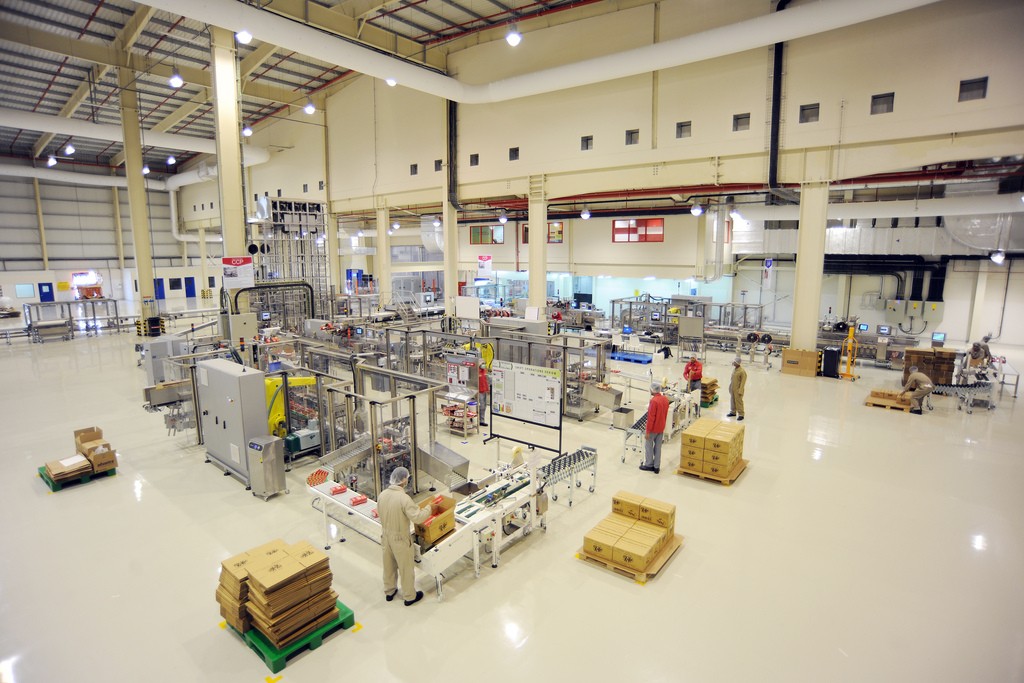 A factory floor, various packing machines and workers visible