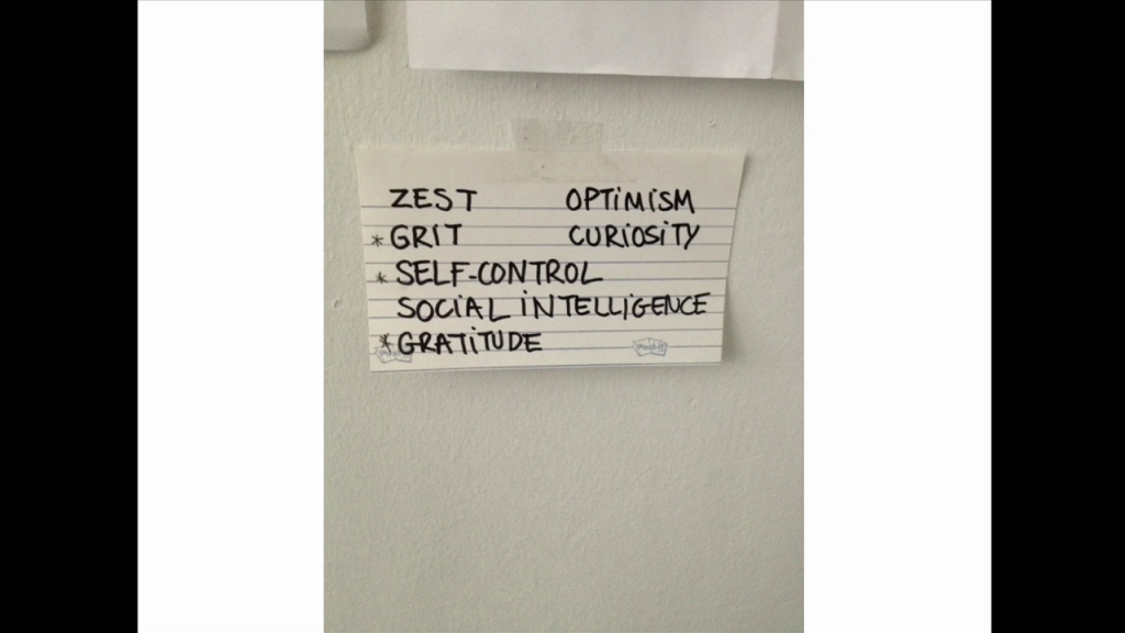 An index card listing: zest, grit, self-control, social intelligence, gratitude, optimism, curiosity