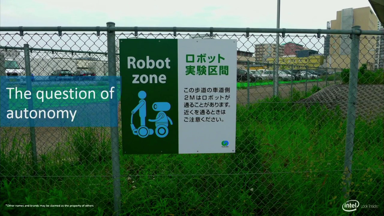 A sign reading "Robot zone" above an illustration of a human on a Segway-like vehicle followed by a robot. There is also some Japanese text. Captioned "The question of autonomy"