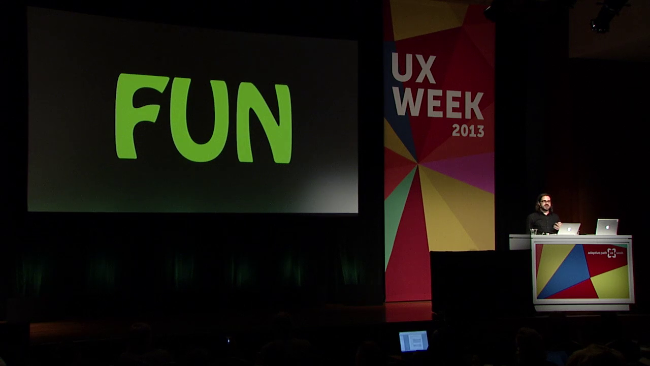 Photo of Ian Bogost during presentation,with a slide displaying the word "Fun" in large letters.