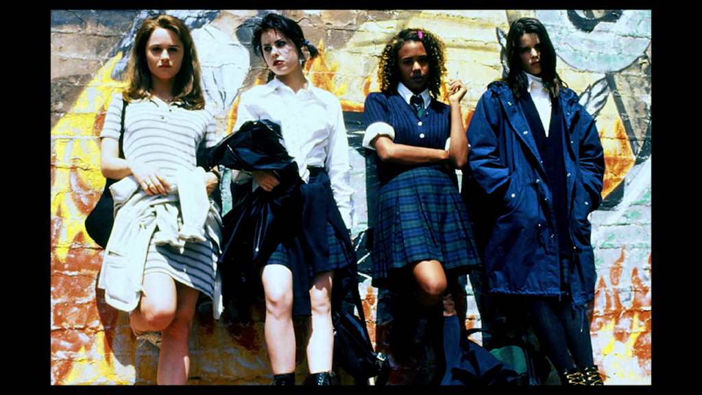 The four lead characters from The Craft, leaning against a wall