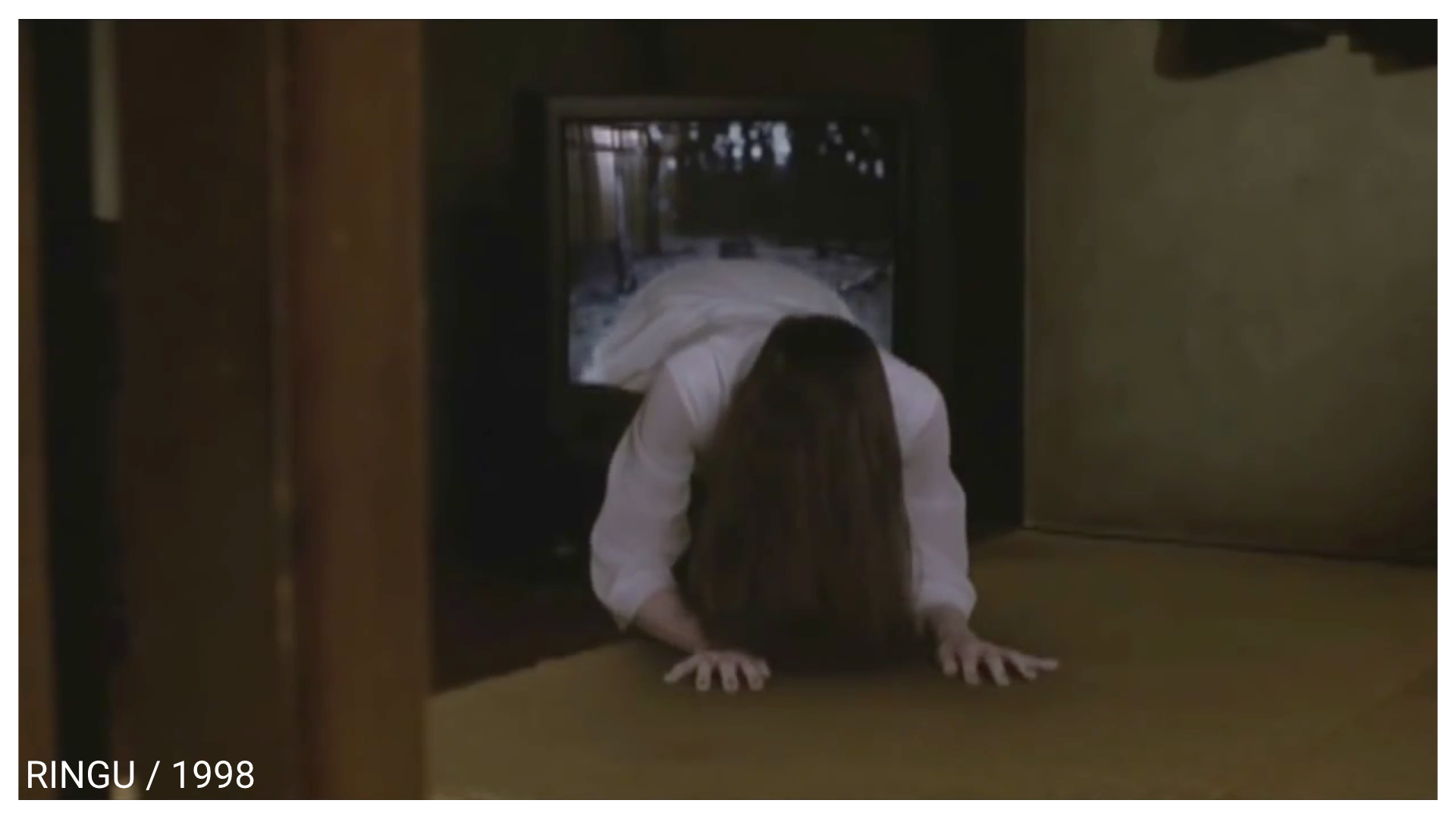 Still from the movie "Ringu" showing a girl with her face obscured by hair crawling out of a television set