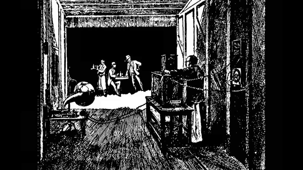 Illustration of people working inside the Black Maria; a man standing next to the camera with a gramaphone nearby; towards the back a group of people around a table
