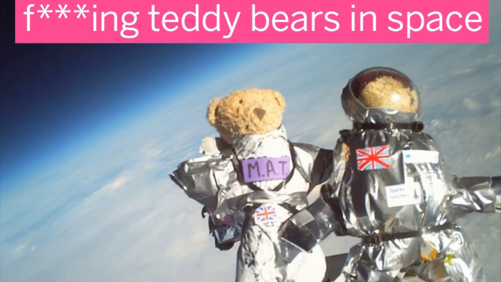Photo of two teddy bears in makeshift spacesuits floating above the Earth, captioned "f***ing teddy bears in space!"
