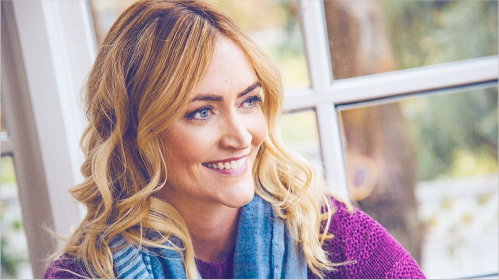 Heather Armstrong herself, next to a window, smiling