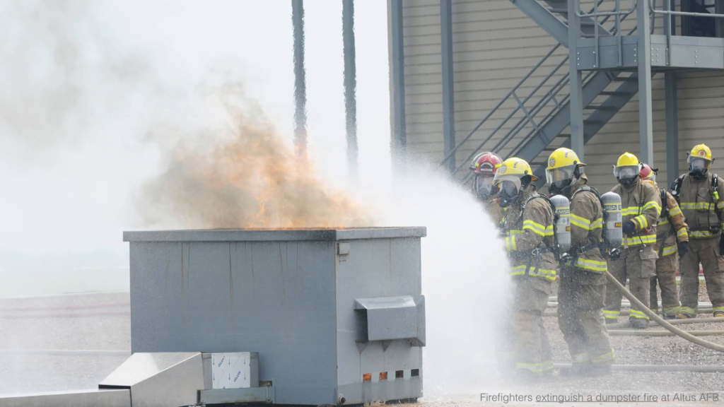 Firefighters extinguising a dumpster fire at Altus AFB