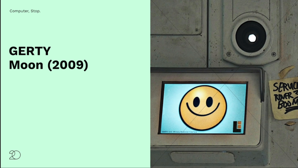 GERTY's interface in the movie Moon, consisting of a screen currently displaying a smiling face emoji, with a small camera visible in the wall above the screen