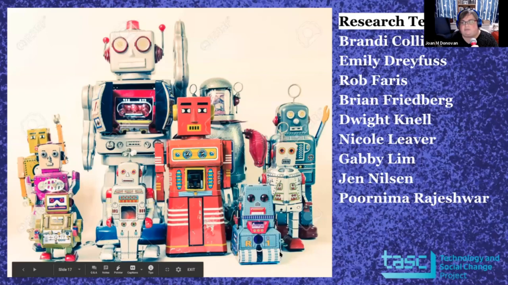 A collection of tin robot toys arranged in a group, some with a raised arm as if waving, next to a list of Donovan's research team: Brandi Collins-Dexter, Emily Dreyfuss, Rob Faris, Brian Friedberg, Dwight Knell, Nicole Leaver, Gabby Lim, Jen Nilsen, Poornima Rajeshwar